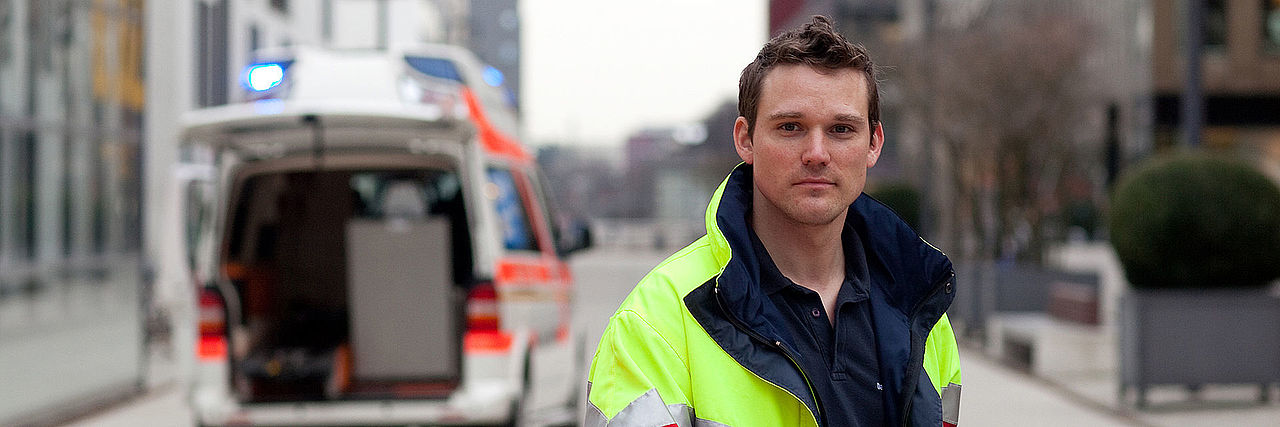 BFD stage img Ein junger Mann in gelber Jacke schaut in die Kamera.