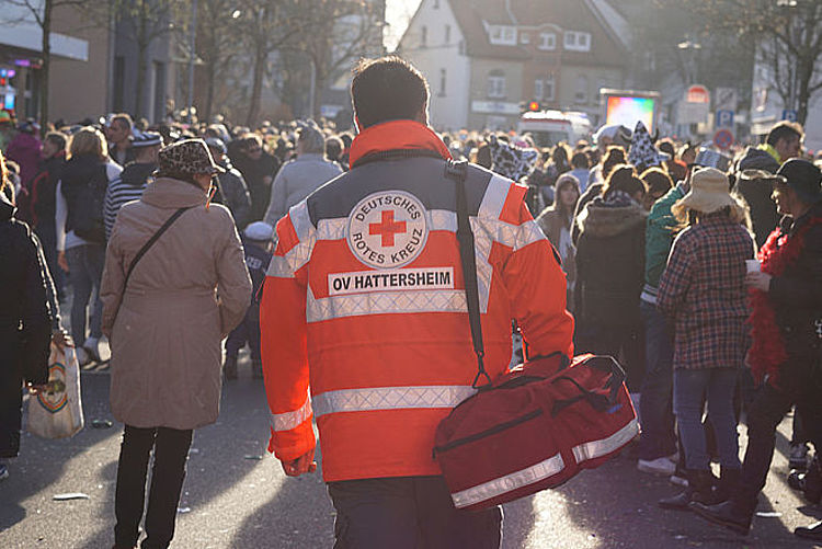 Hattersheim content img Mitarbeiter des DRK mit roter Einsatzjacke läuft in einer Menschenmenge.