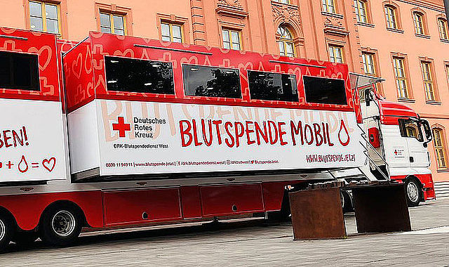 Blutspende resource img Ein rot-weißer Blutspendebus des DRK mit Werbeschriftzug für die Blutspende.