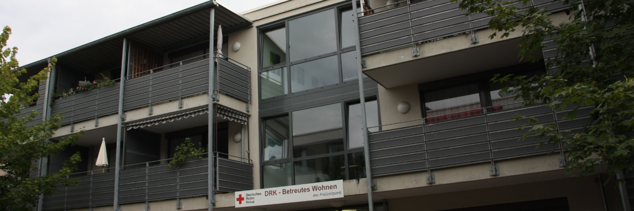 BW stage_image Der Eingang des Betreuten Wohnen Kriftel und die Balkone des Gebäudes.